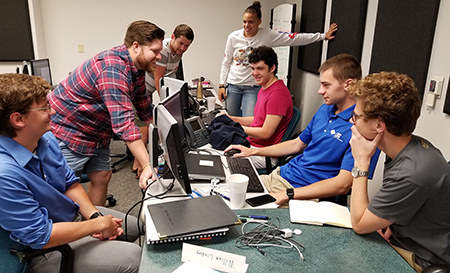 In the LRS training room that has become their office, members of the internship program discuss their work. From left to right are Dryden Steele, Jordan Shifflett, Danny Munson, SIUE’s Lyric Boone, Josh Matchuny, Will Lindsey and Alex Cawley. SIUE’s Spencer Lemay was unavailable for the photo.